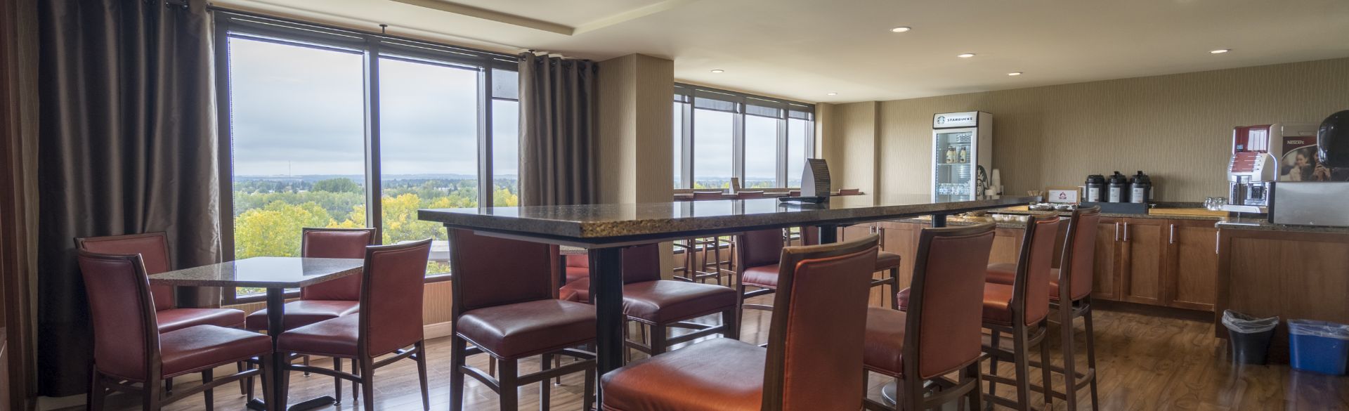 Expansive VLT lounge featuring refrigerators, a coffee bar, and delectable food amidst breathtaking natural surroundings and picturesque mountain vistas.